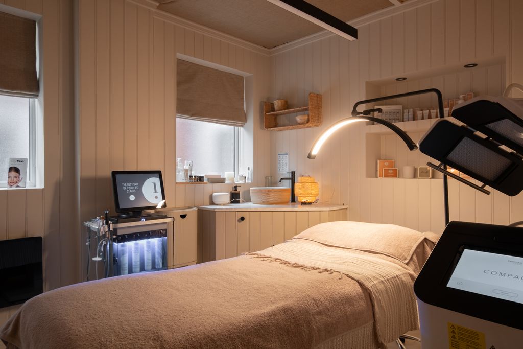 The facial room with the Hydrafacial system and Dermalux LED beside the treatment couch